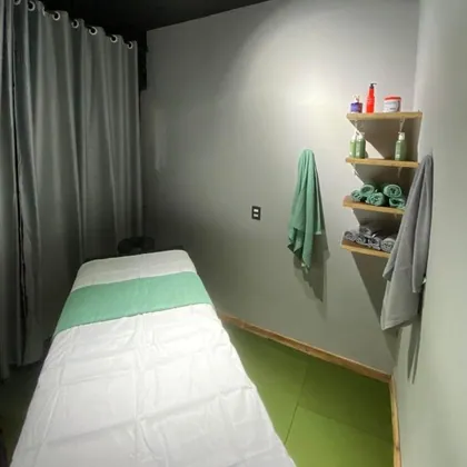 Sala de massagem com maca e toalhas