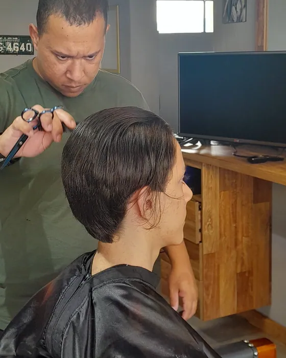 Barbeiro da Hakon finalizando um corte com tesoura e pente