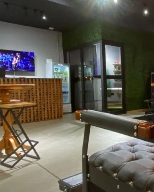 Bar da Hakon com TV, balcão de madeira e geladeira de bebidas