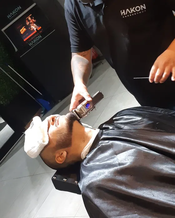 Cliente com toalha quente no rosto durante a barboterapia